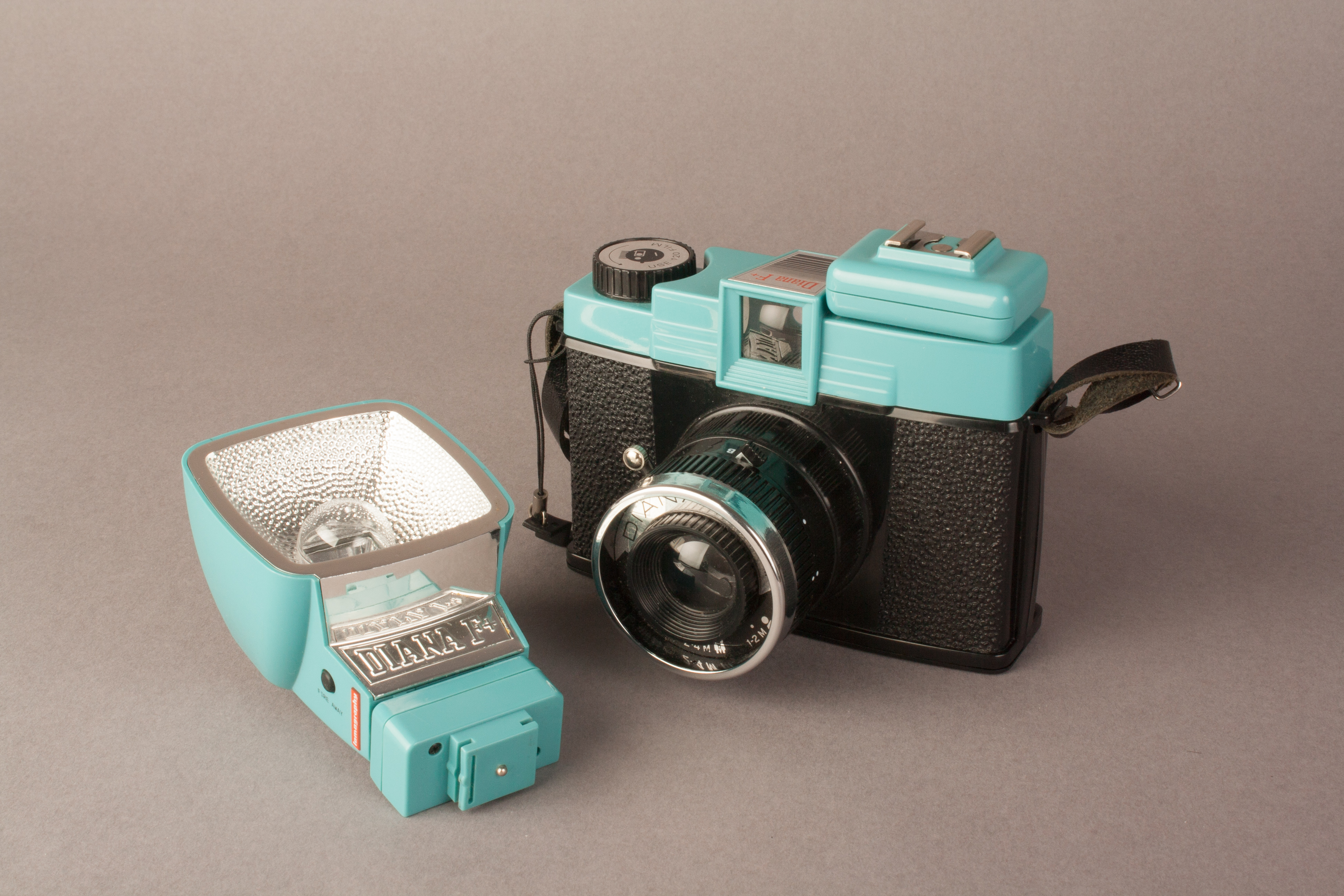 A picture showing the diana F+ with the hot shoe adapter, next to the flash with its own hot shoe adapter