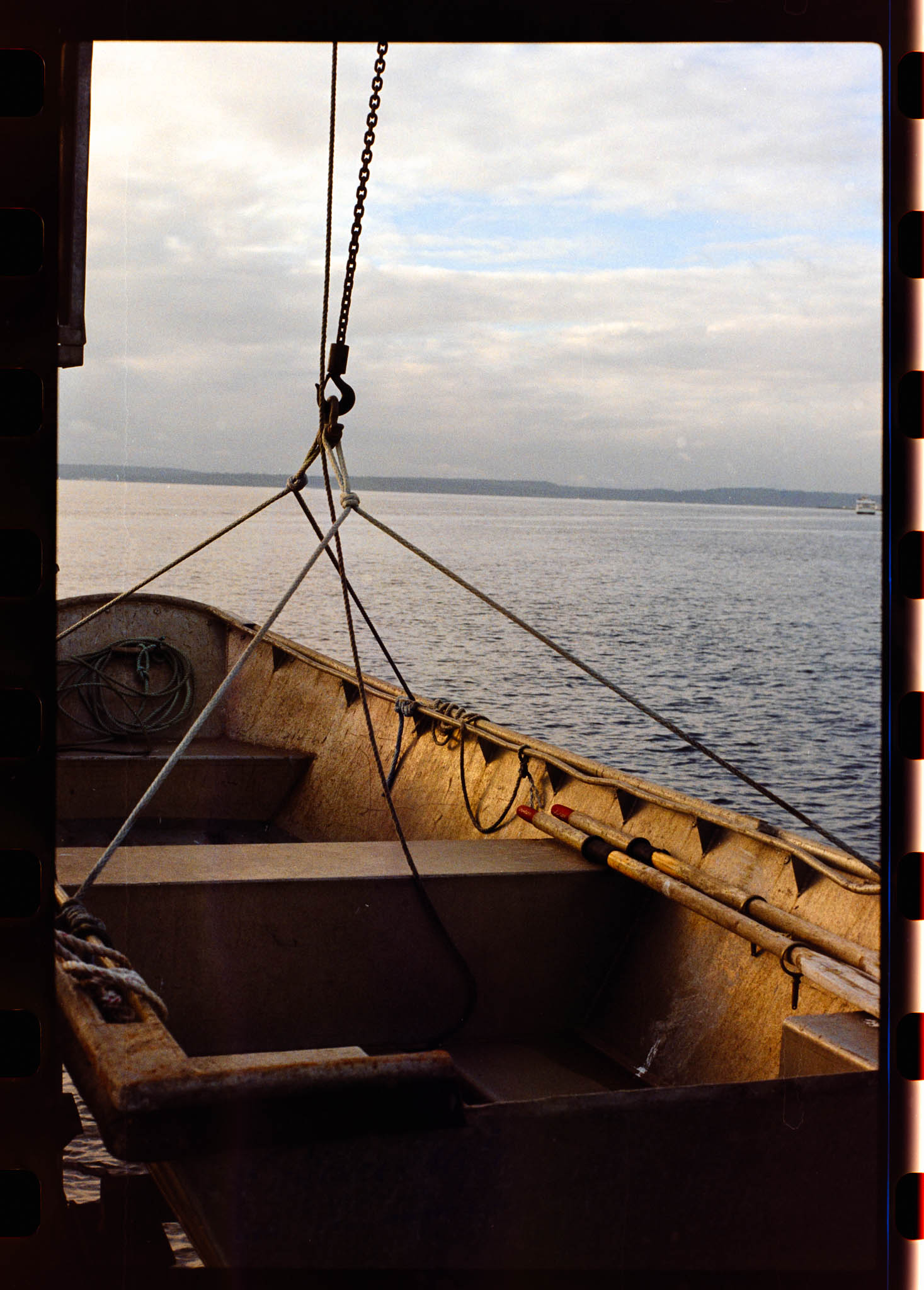 Color image of a boat suspended by a crane over elliot bay 