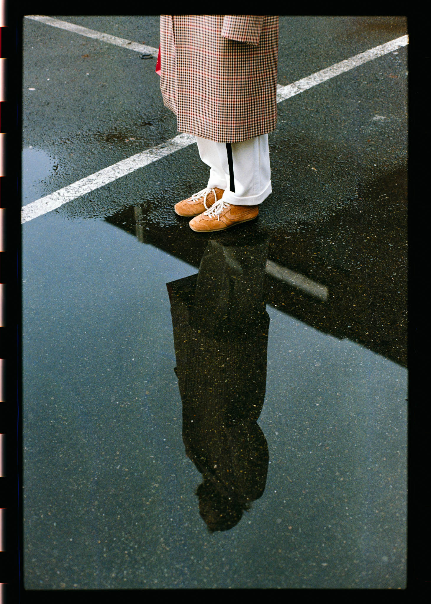 Color image of a reflection of a woman in a puddle