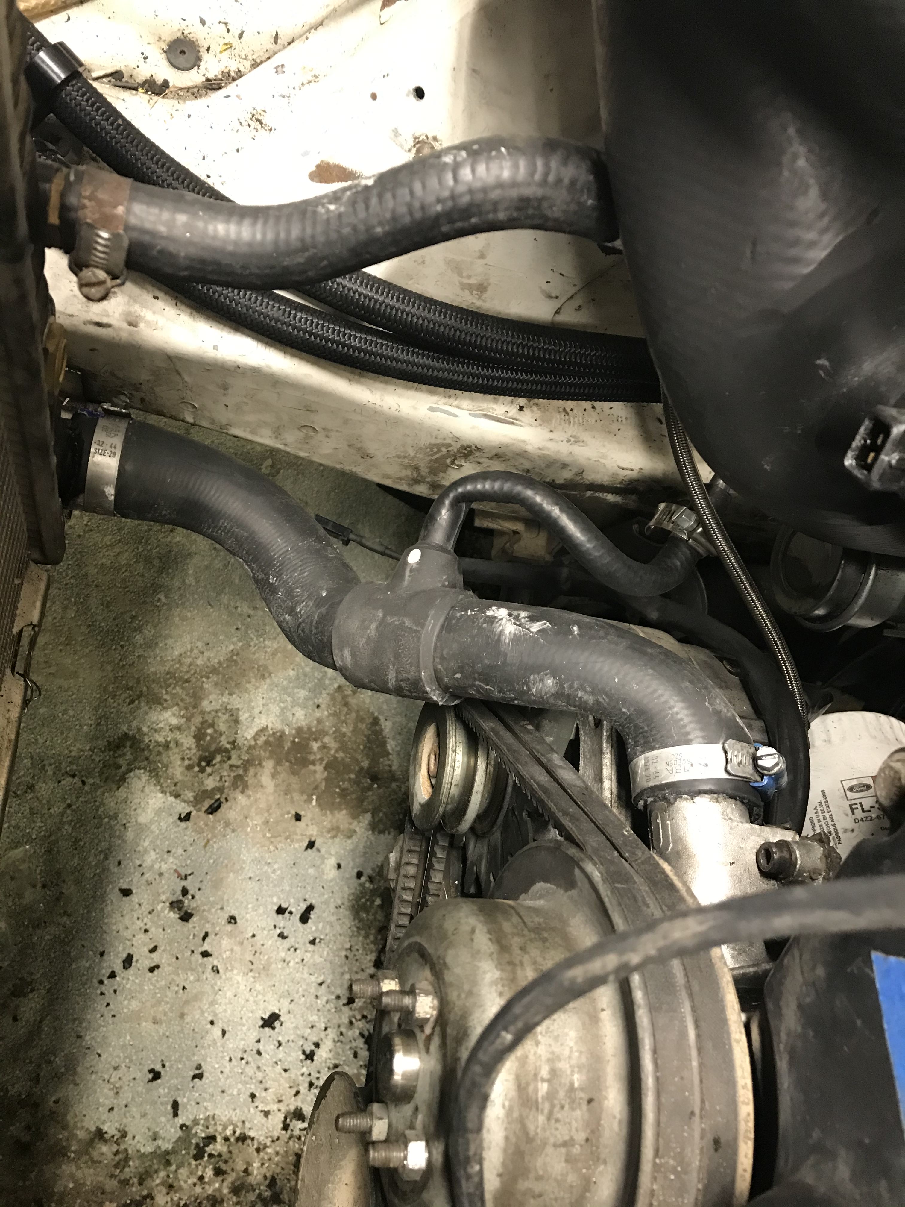 Engine bay showing lower radiator hose with a tee fitting